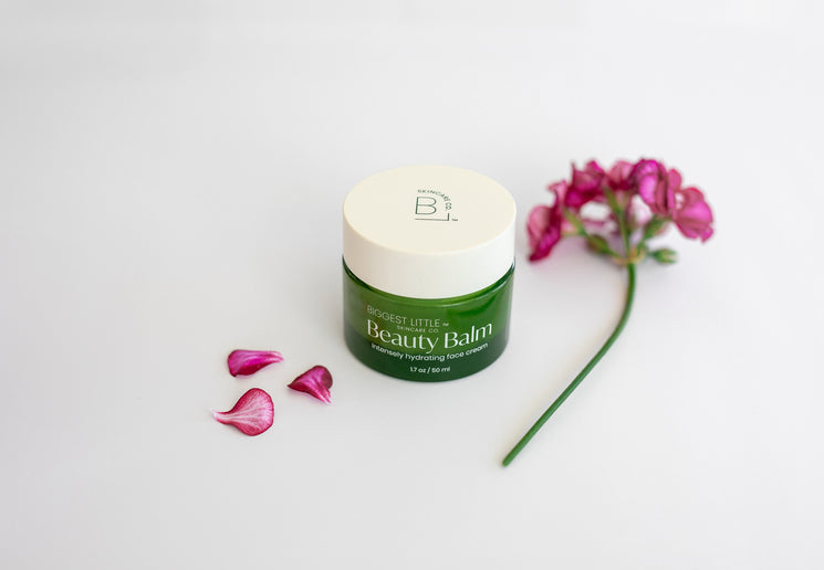 Jar of Beauty Bal surrounded by geranium flowers
