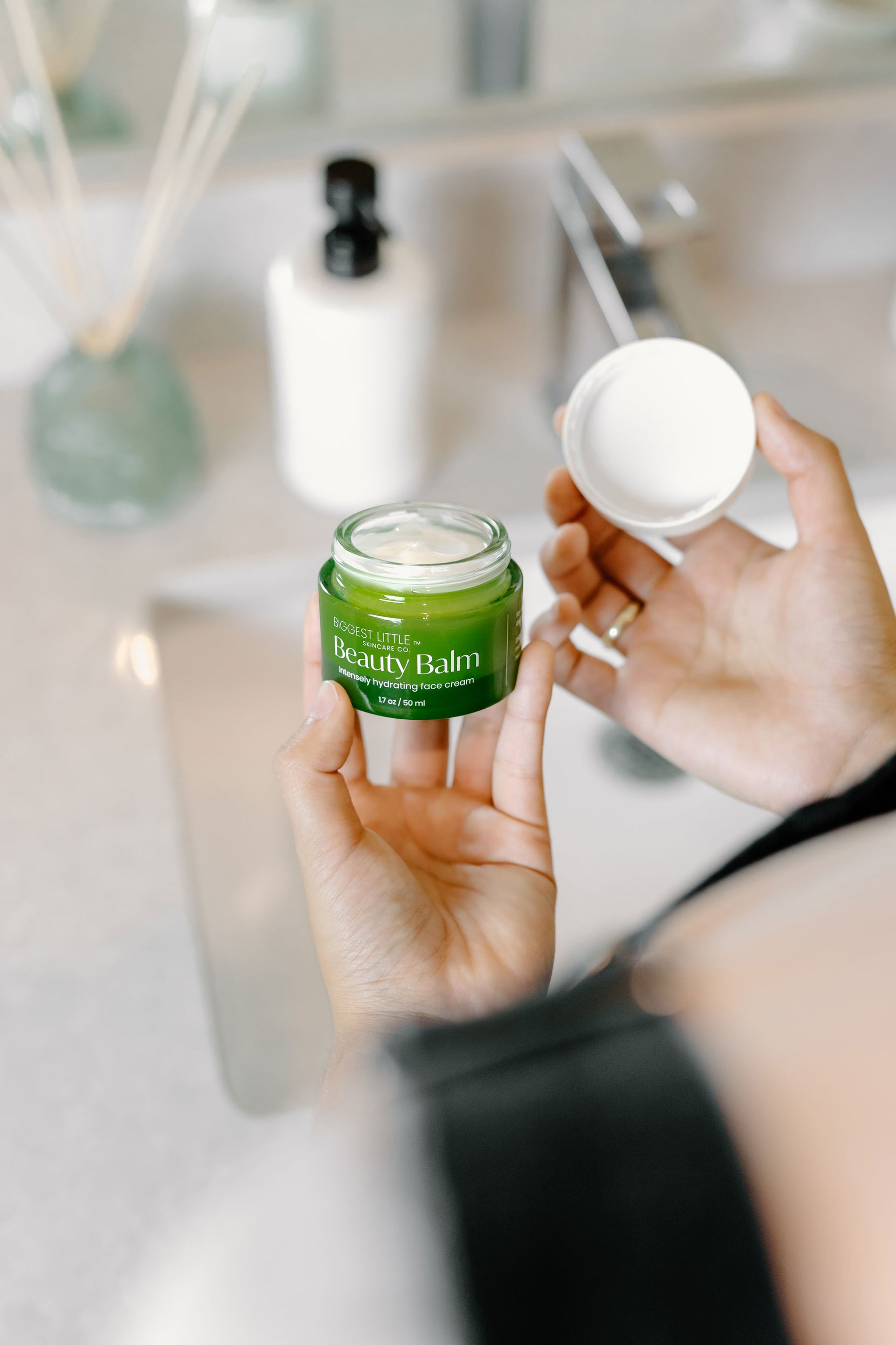 person with BLSCO Beauty Balm jar on their hands